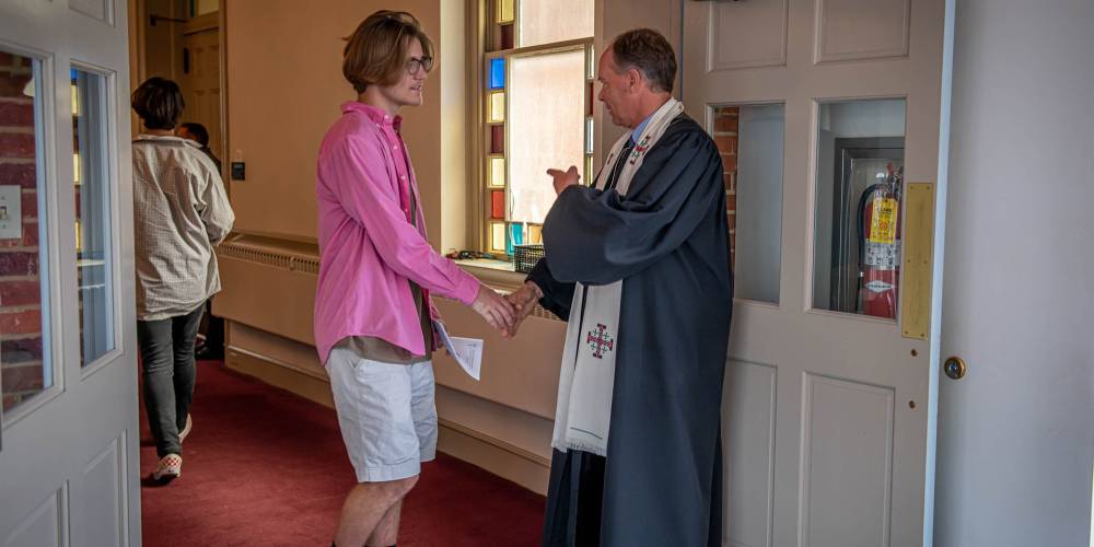 Pastor interacting with young man after Sunday service