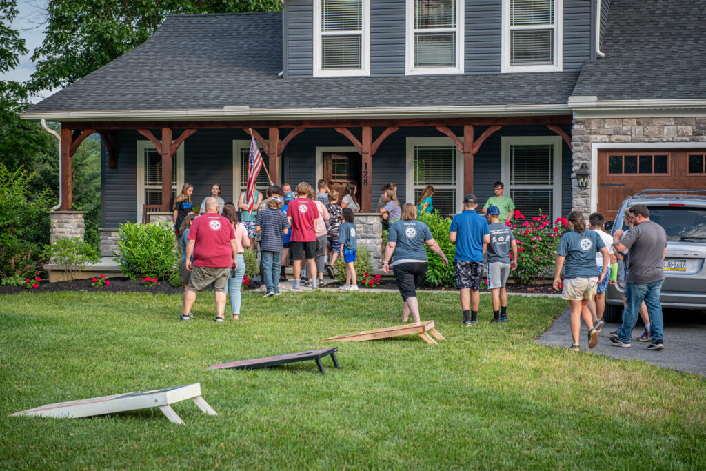 Students gathering on the lawn of a home